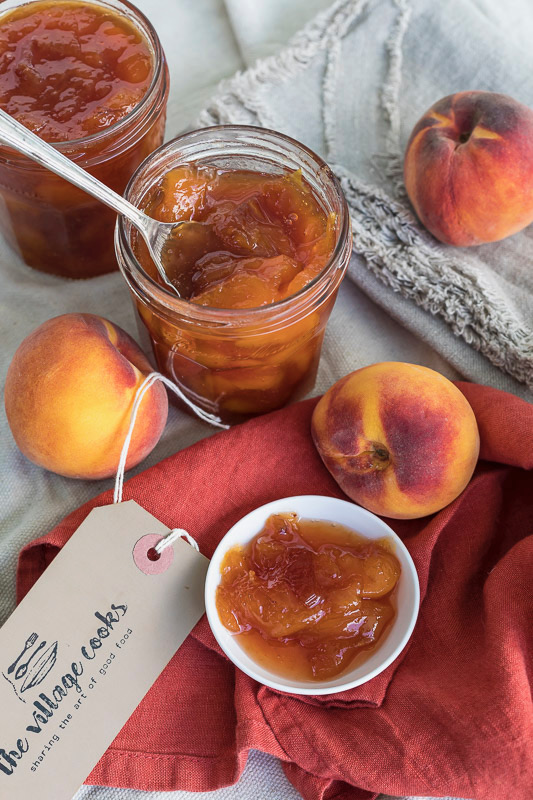 Homemade peach jam in jars, with fresh peaches